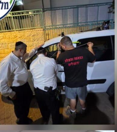 מתנדבים מסייעים ליד רכב