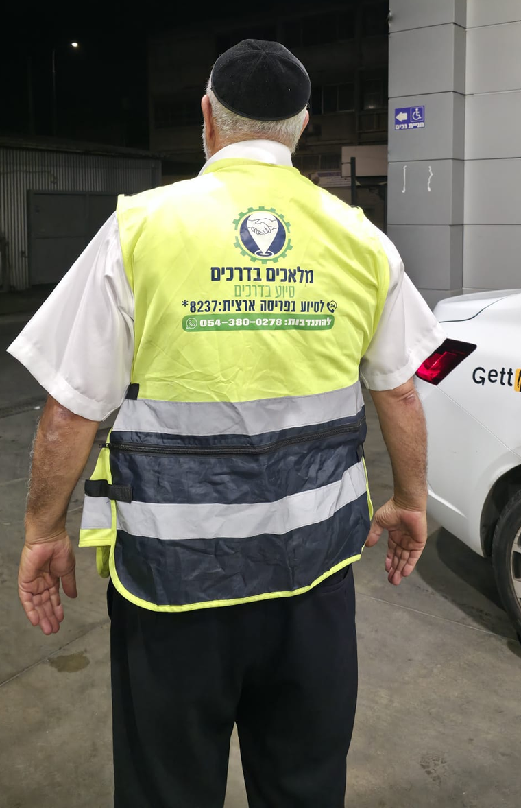 מתנדב מלאכים בדרכים באפוד הארגון בקריאה לילית